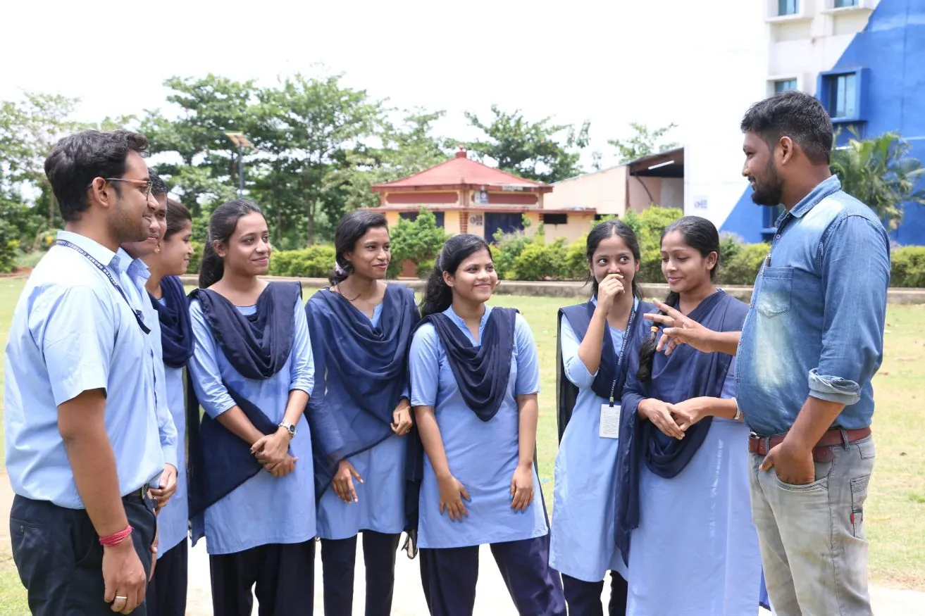 Students in discussion with two faculty members outdoors.