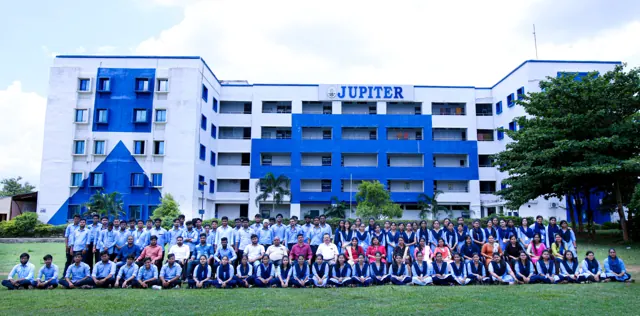 Students gathered for a group photo on the lawn in front of the college building.