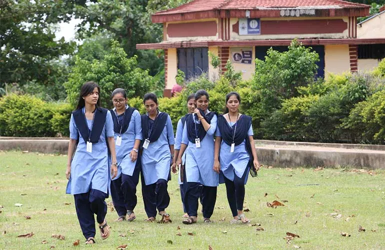 A group of students walking across the campus grounds.