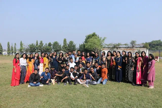 Students in festive dress gathered on the campus lawn for a group photo.