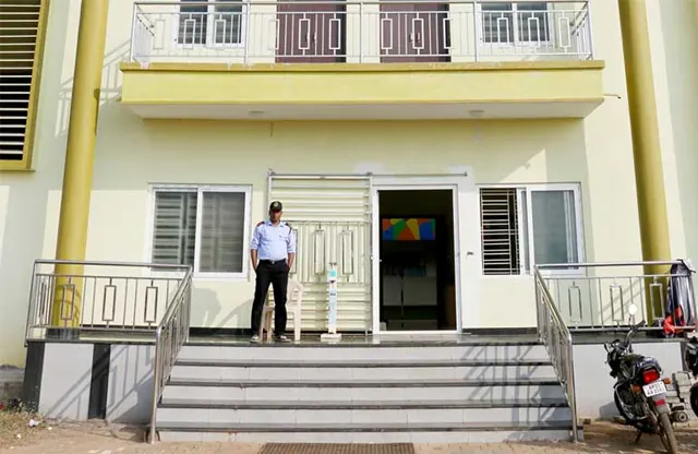 A hostel entrance with a security guard on duty at the door.