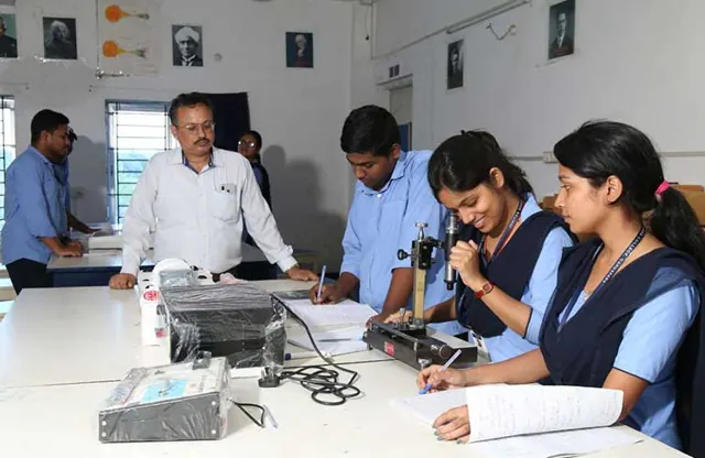 A faculty member guiding students through a physics experiment.